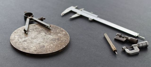 Beispielfoto: Messschieber, Zirkel und Messschrauben auf dunklem Grund