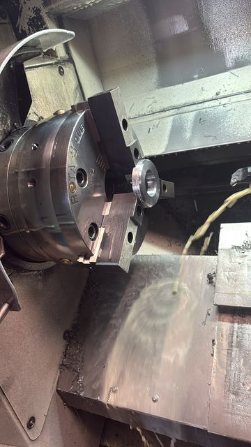 Drehen von Passscheiben im Dreibackenfutter der CNC-Drehmaschine, Kühlschmierstoff läuft