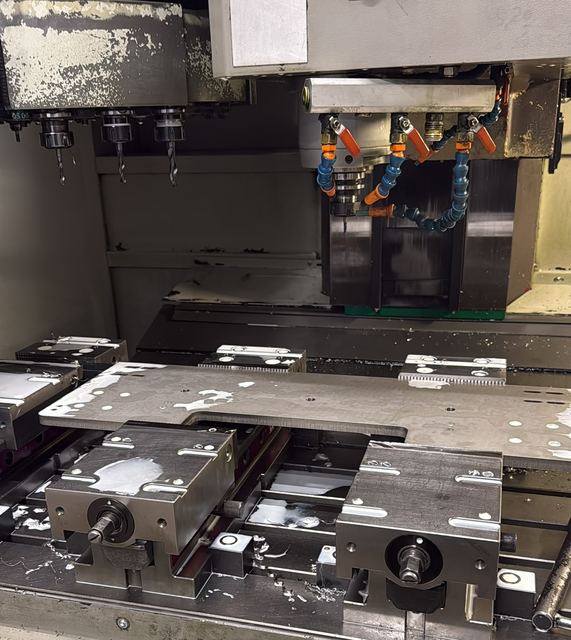 CNC-Fräsmaschine mit Werkzeugwechsler, großes Blech in zwei Schraubstöcken gespannt