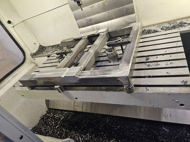 Mechanische Bearbeitung eines Schweißgestells auf dem Tisch der CNC-Fräsmaschine