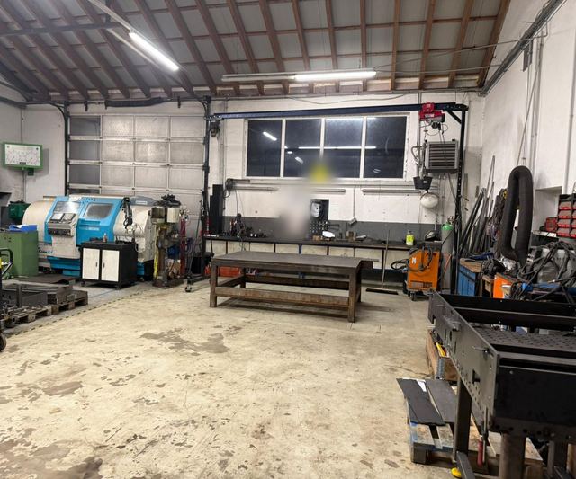Werkhalle mit CNC-Drehmaschine, Schweißtisch und Portalkran